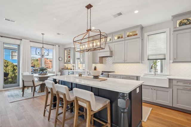 kitchen featuring sink, hanging light fixtures, plenty of natural light, and a kitchen island