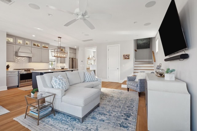 living room featuring light hardwood / wood-style floors and ceiling fan