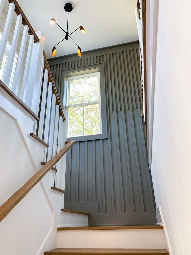 staircase with a notable chandelier