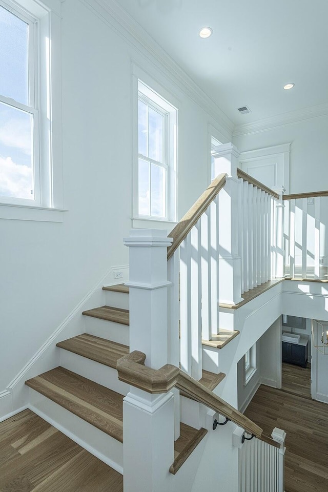 stairs featuring visible vents, wood finished floors, and a wealth of natural light