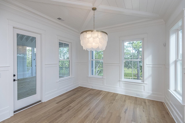 unfurnished dining area featuring a decorative wall, a notable chandelier, and a healthy amount of sunlight