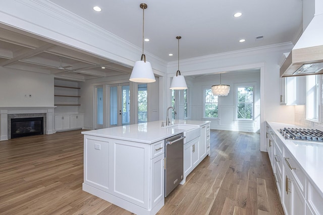 kitchen with a sink, stainless steel appliances, open floor plan, white cabinetry, and custom exhaust hood