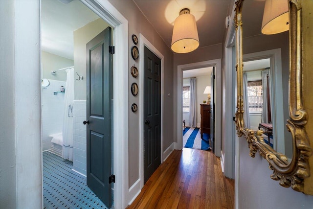 hall featuring baseboards and wood finished floors