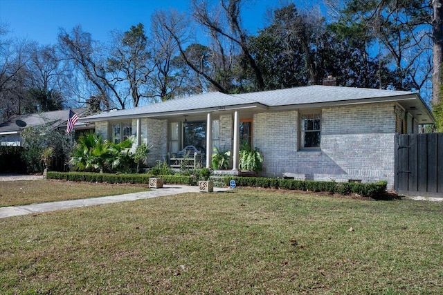 ranch-style home with a porch, brick siding, and a front lawn