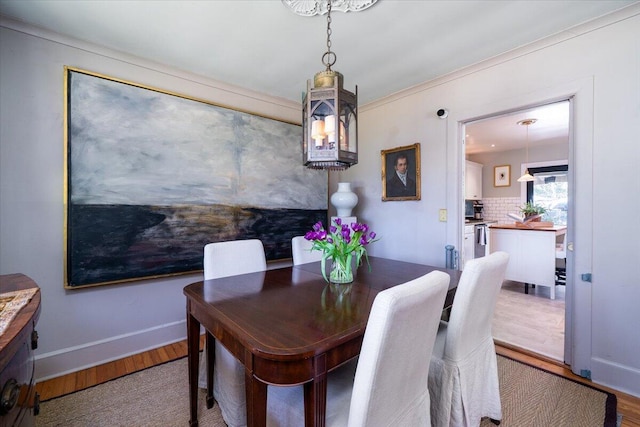 dining space featuring light wood-style flooring and baseboards