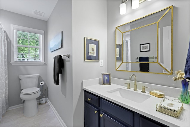bathroom featuring toilet, vanity, and baseboards