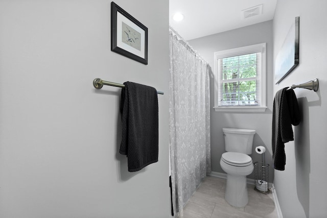 bathroom featuring toilet, baseboards, tile patterned flooring, and a shower with shower curtain