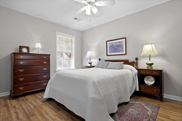 bedroom with baseboards, wood finished floors, and ceiling fan