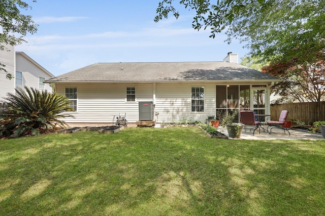 back of property featuring a patio area, a chimney, a sunroom, and roof with shingles