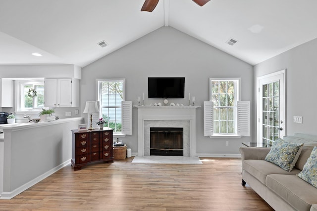 living room featuring a ceiling fan, light wood-type flooring, lofted ceiling, plenty of natural light, and recessed lighting