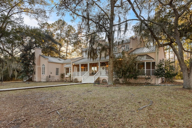 view of front of home featuring covered porch and a front lawn