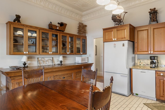 dining area featuring ornamental molding and light tile flooring