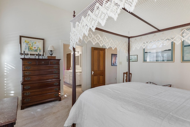 bedroom with light colored carpet and connected bathroom