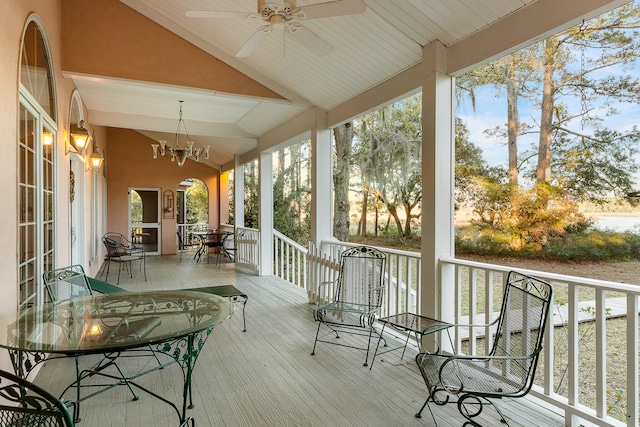 sunroom featuring lofted ceiling and ceiling fan with notable chandelier