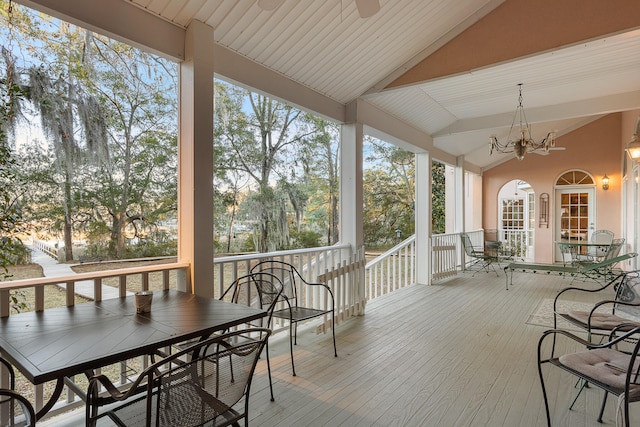 sunroom / solarium featuring lofted ceiling and ceiling fan with notable chandelier