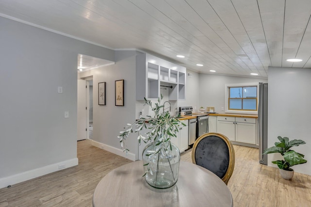 dining area with crown molding and light hardwood / wood-style flooring