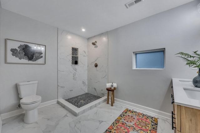 bathroom with vanity, a tile shower, and toilet