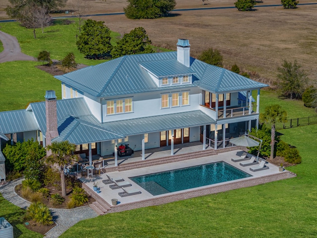 rear view of property featuring a patio area and a lawn