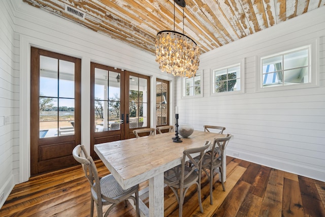 dining area featuring french doors, dark hardwood / wood-style flooring, and a notable chandelier