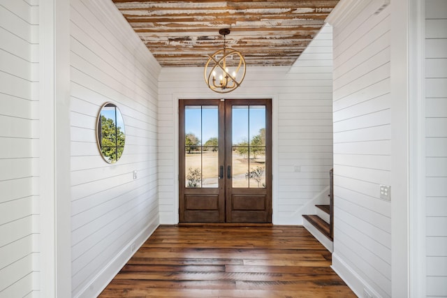 entryway with french doors, dark wood-type flooring, and a chandelier