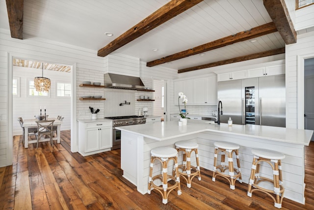 kitchen featuring white cabinetry, an inviting chandelier, a breakfast bar, high end appliances, and tasteful backsplash