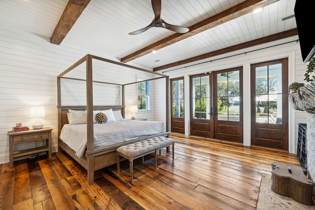 bedroom featuring ceiling fan, beamed ceiling, access to outside, french doors, and dark hardwood / wood-style flooring