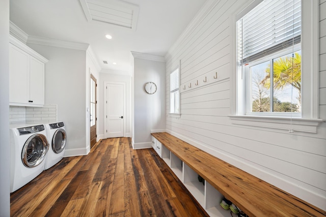 laundry room featuring washing machine and dryer, dark wood-type flooring, cabinets, and crown molding