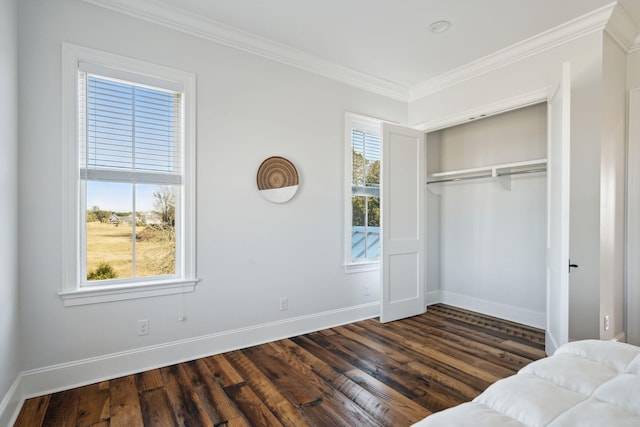 bedroom featuring crown molding, dark wood-type flooring, and a closet