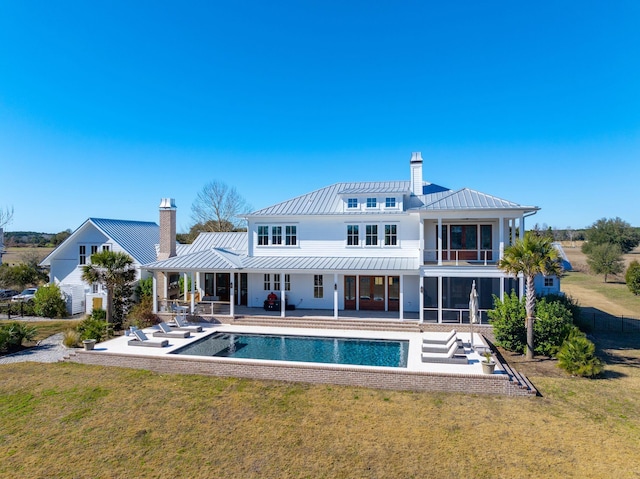 rear view of property featuring a lawn and a patio