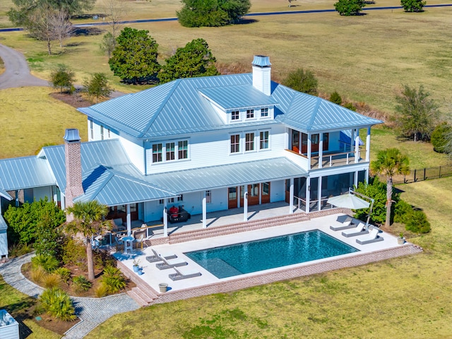 rear view of property with a sunroom, a yard, and a patio area