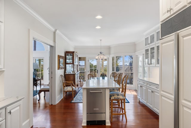 dining space with an inviting chandelier, crown molding, and dark hardwood / wood-style floors