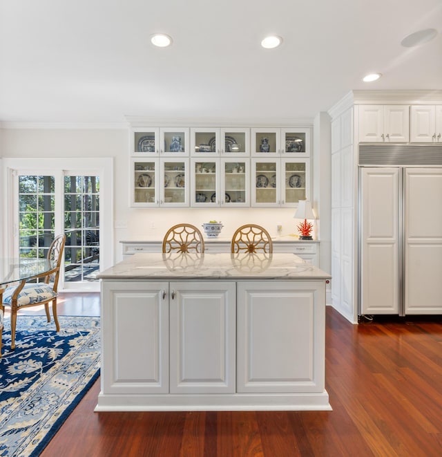 bar featuring ornamental molding, dark hardwood / wood-style flooring, white cabinets, and light stone counters