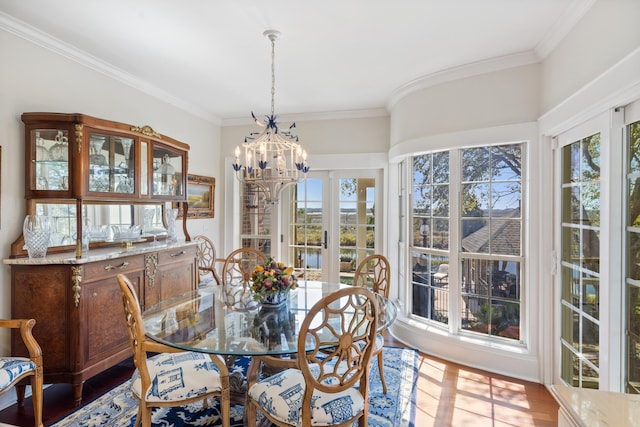 dining space featuring a wealth of natural light, crown molding, and an inviting chandelier