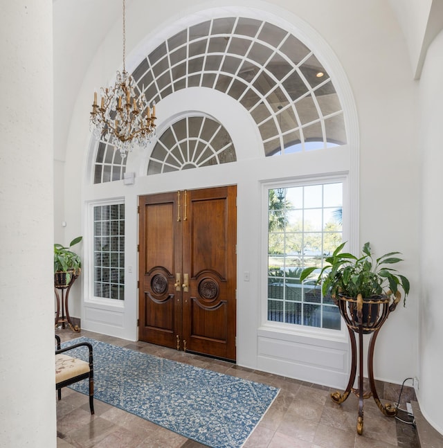 entryway with tile floors and a chandelier