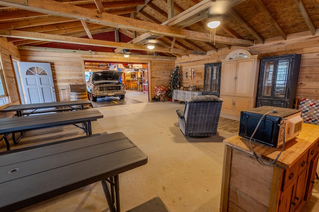 miscellaneous room featuring lofted ceiling and wood walls