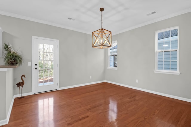 unfurnished room featuring hardwood / wood-style flooring, ornamental molding, and a notable chandelier