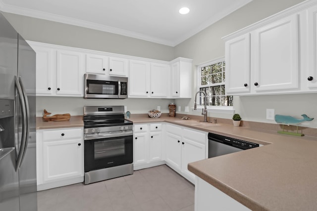 kitchen featuring sink, crown molding, light tile patterned floors, stainless steel appliances, and white cabinets