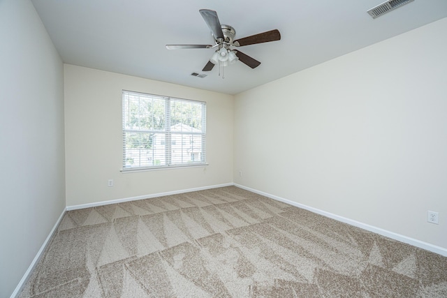 spare room featuring carpet floors, baseboards, visible vents, and a ceiling fan