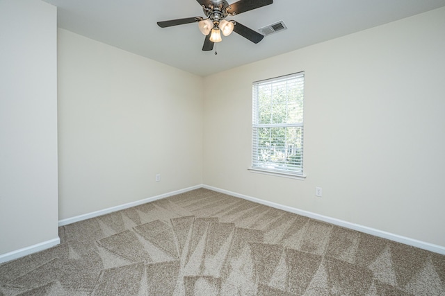 empty room featuring carpet floors, a ceiling fan, visible vents, and baseboards