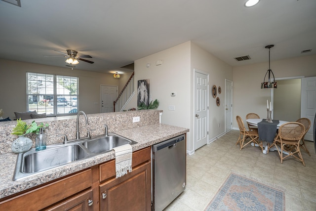 kitchen featuring visible vents, decorative light fixtures, light countertops, stainless steel dishwasher, and a sink