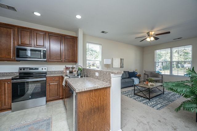 kitchen with visible vents, appliances with stainless steel finishes, open floor plan, light countertops, and a sink