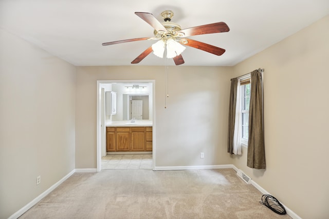 carpeted spare room featuring sink and ceiling fan