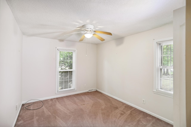 carpeted empty room with a textured ceiling and ceiling fan