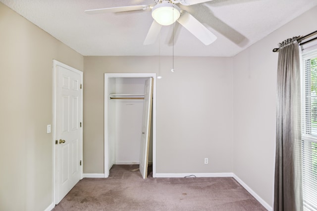 unfurnished bedroom featuring light colored carpet, a closet, and ceiling fan