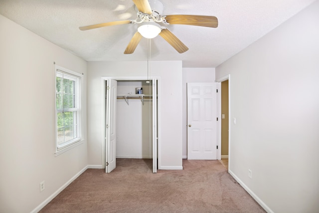 unfurnished bedroom featuring carpet floors, a textured ceiling, ceiling fan, and a closet