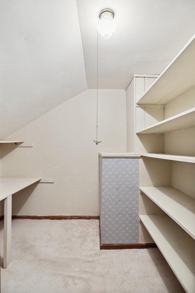 spacious closet featuring lofted ceiling and light carpet