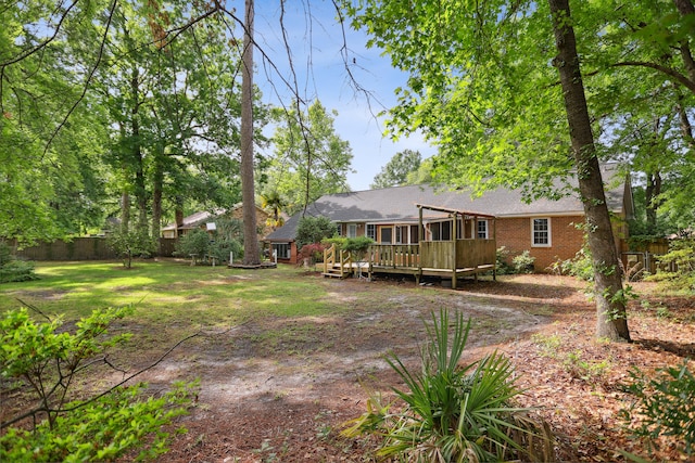 back of property featuring a wooden deck and a lawn