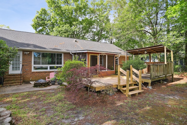 rear view of property featuring a pergola, an outdoor fire pit, and a deck