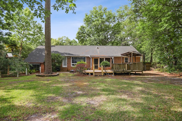 rear view of property featuring a wooden deck and a yard