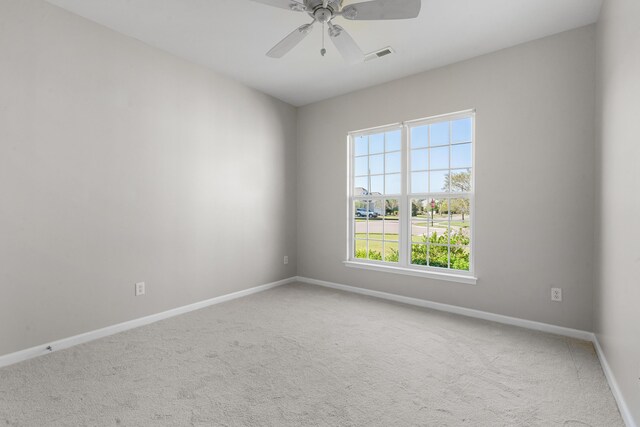 unfurnished room featuring a wealth of natural light, ceiling fan, and light colored carpet